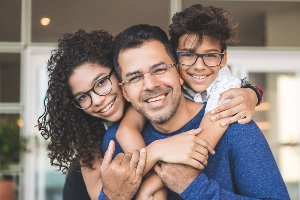 father and two children smiling and embracing