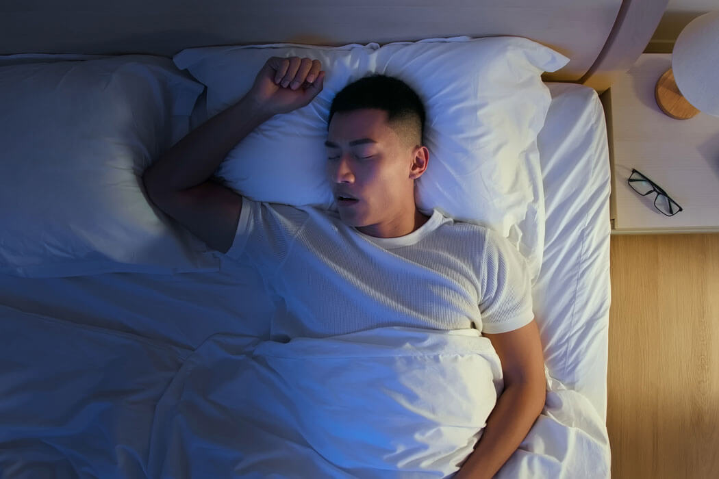 man with sleep apnea snoring at night in his bed