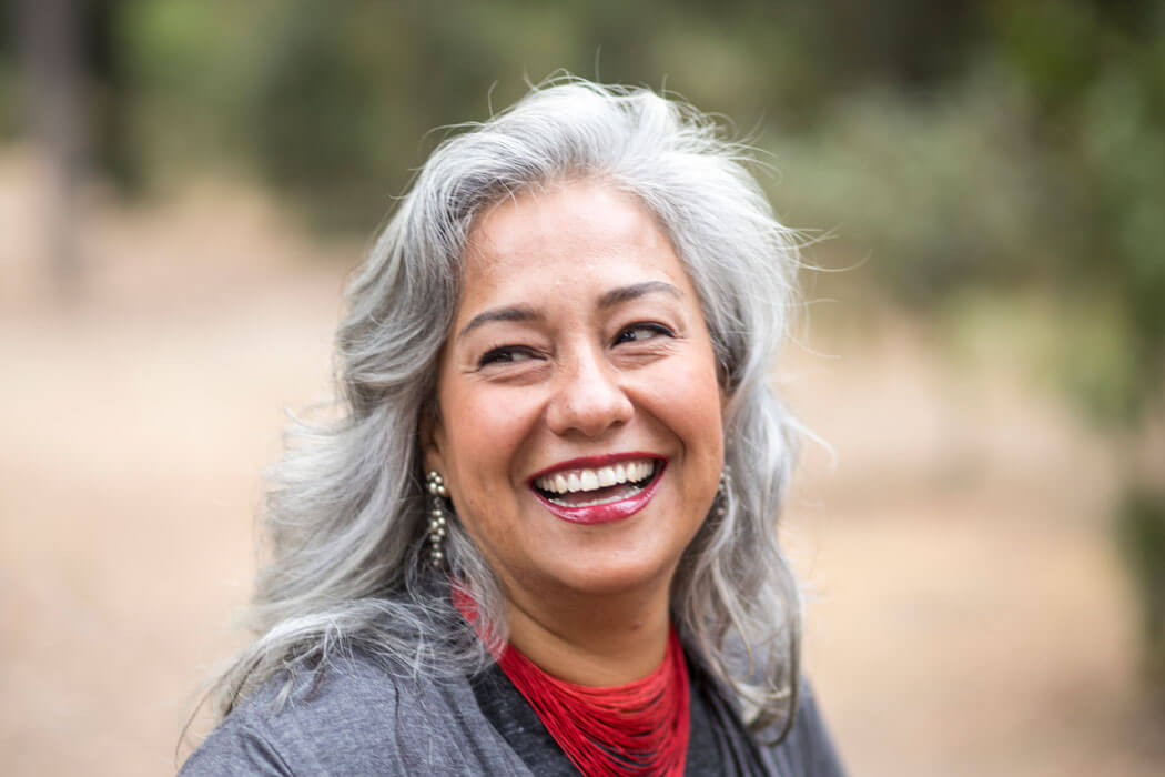 senior woman with white hair smiling and laughing outdoors